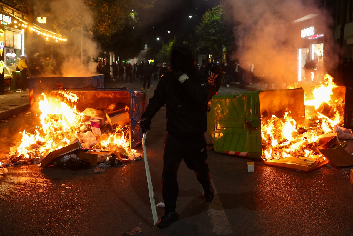 Διαδηλωτής ανάμεσα σε πυρπολημένους κάδους στη διάρκεια αντικυβερνητικής διαδήλωσης στα Τίρανα στις 17 Οκτωβρίου 2026